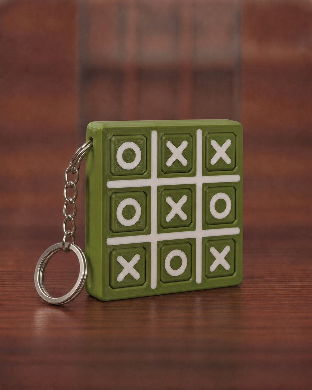 Tic Tac Toe Keychain in Matt Olive Green with Matt Off-white X, O and grid lines, keyring attached through the side edge