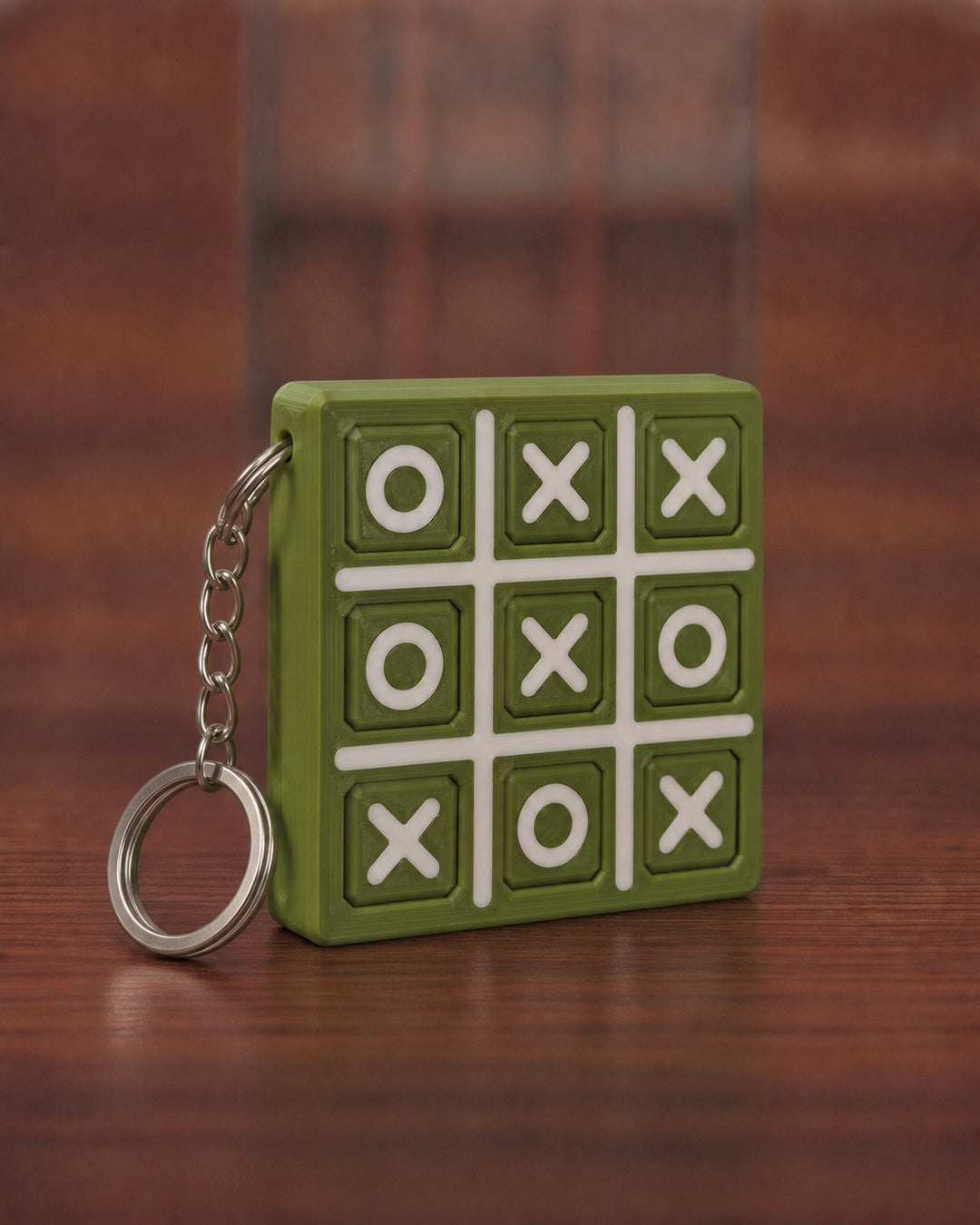 Tic Tac Toe Keychain in Matt Olive Green with Matt Off-white X, O and grid lines, keyring attached through the side edge
